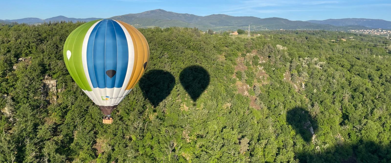 Ombres de montgolfières Montgolfières & Cie projetées sur une forêt ardéchoise.